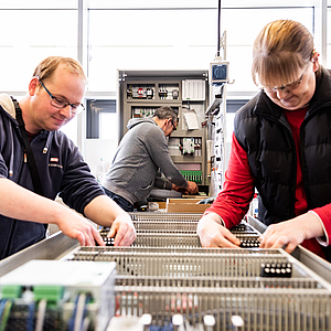 Mitarbeiter:innen der Werkstatt Afferde bei der Arbeit im Bereich "Elektrotechnik"