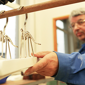 Mitarbeiter der Gerd-Halhbrock-Werkstatt sortiert Bügel