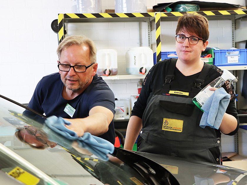 zwei Arbeiter in der Fahrzeugpflege bei der Autoreinigung