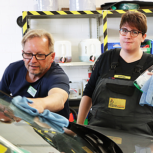 zwei Arbeiter in der Fahrzeugpflege bei der Autoreinigung