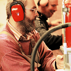 zwei Männer mit Gehörschutz arbeiten in der Gerd-Hahlbrock-Werkstatt