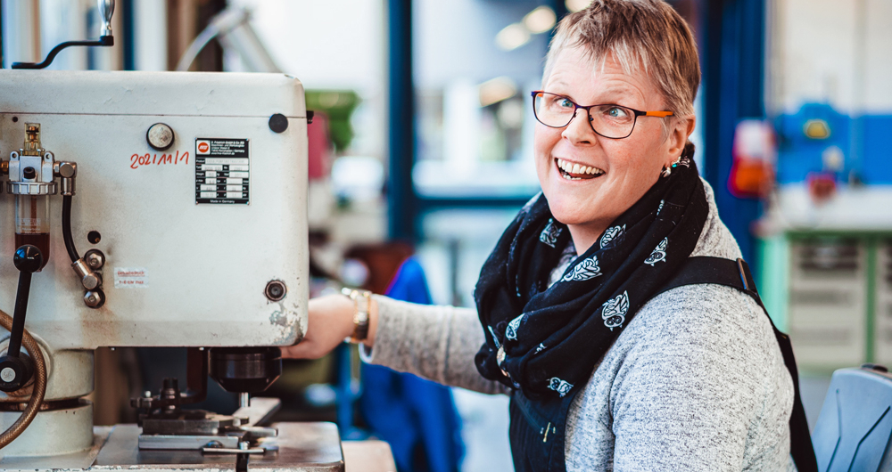 Mitarbeiterin der Werkstatt an einer Maschine