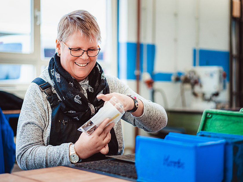 glückliche Frau arbeitet in der Lothar-Wittko-Werkstatt