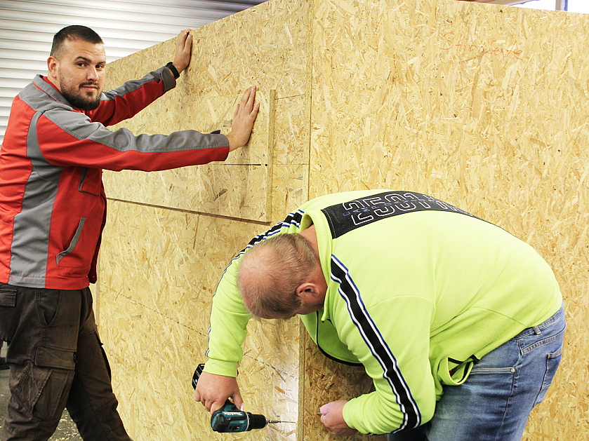 zwei Arbeiter befestigen eine Wand – SCHICHTWECHSEL