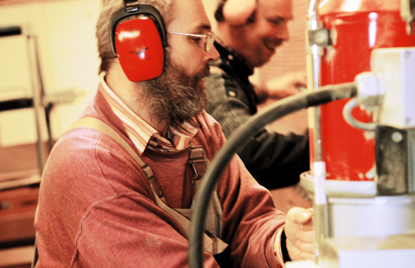 zwei Männer mit Gehörschutz arbeiten in der Gerd-Hahlbrock-Werkstatt