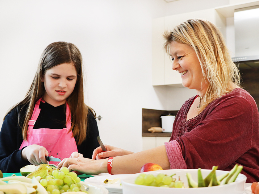 ATISTA-Mitarbeiterin und Mädchen machen Obsalat