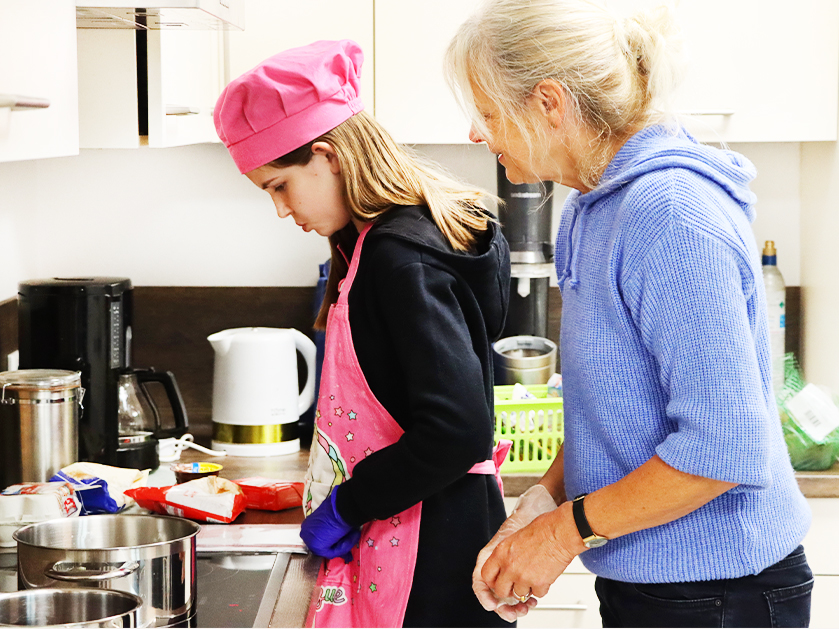 ATISTA-Mitarbeiterin und Mädchen beim Backen