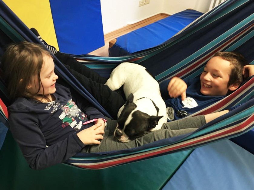 Kinder liegen mit Hund in einer Hängematte in der ATISTA Holzminden