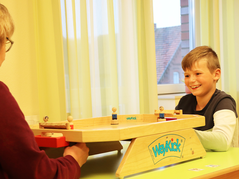 ATISTA-Mitarbeiterin und Junge spielen WeyKick
