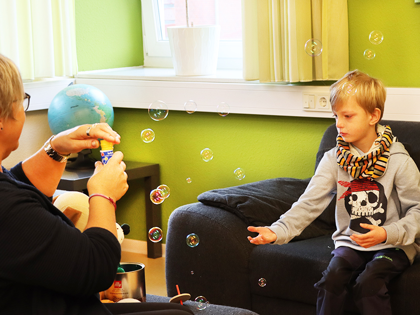 ATISTA-Mitarbeiterin und Junge beim Seifenblasen machen