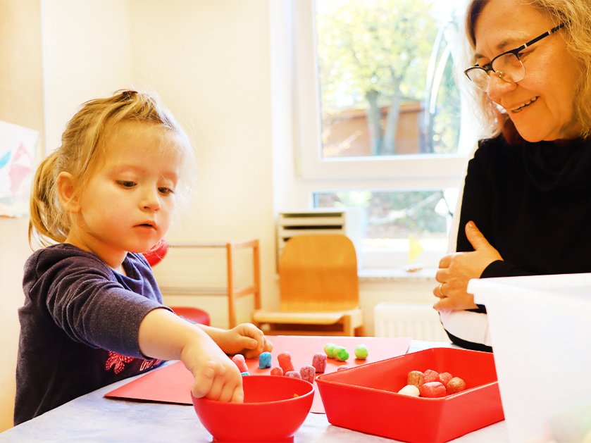 Frühförderin und kleines Mädchen beim Basteln