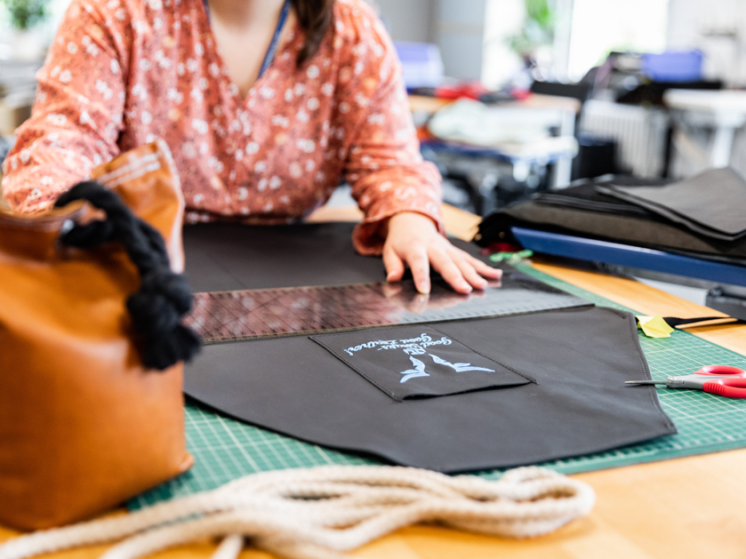 Mitarbeiterin bei der Herstellung von Lederbeuteln