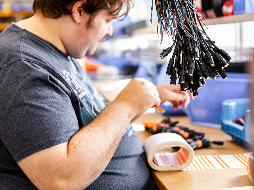 Mitarbeiter beim Einrollen und Etikettieren von Kabeln