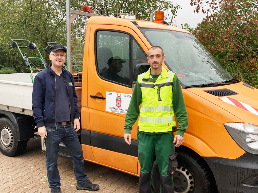 zwei Arbeiter stehen vor einem PKW – SCHICHTWECHSEL