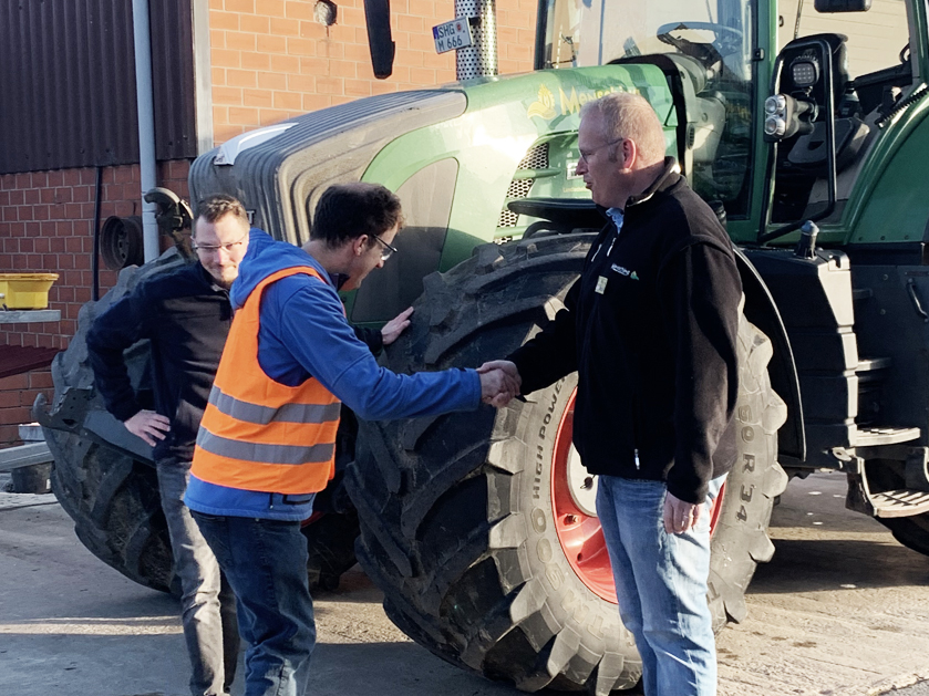 drei Männer vor einem Trecker
