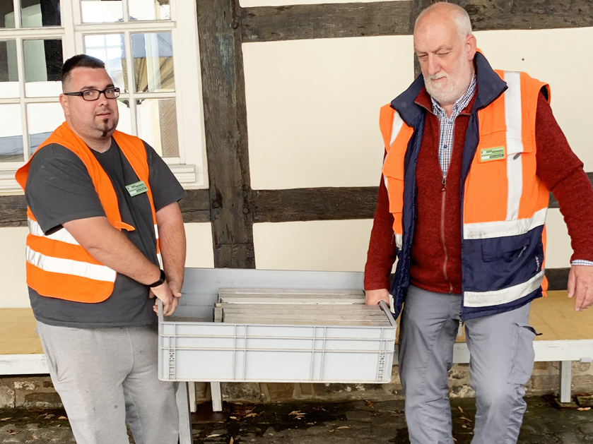 zwei Männer tragen eine Kiste