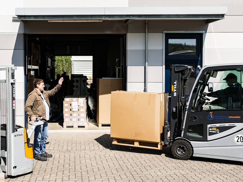 zwei Männer beim Einlagern Ware mit dem Gabelstapler