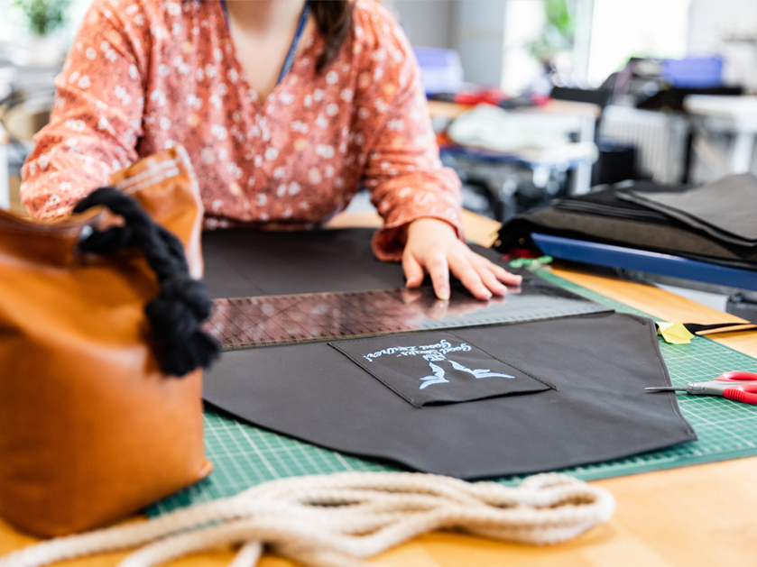 eine Frau misst ein Leder-Stück aus