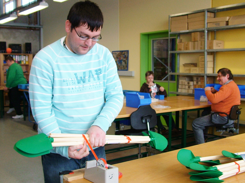 Mitarbeiter der Werkstatt Afferde verpackt Schaufeln
